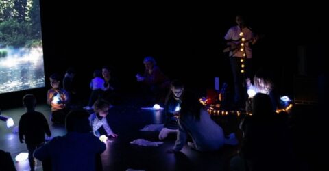 enfants dans une salle sombre, écoutant la musicienne Najoi Bel Hadj, ambiance sensorielle