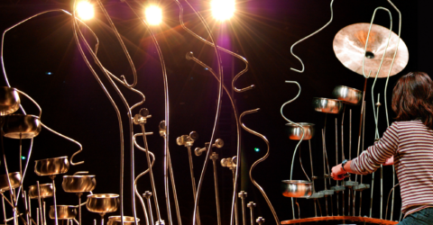 Femme jouant sur une sculpture sonore en formes de visages