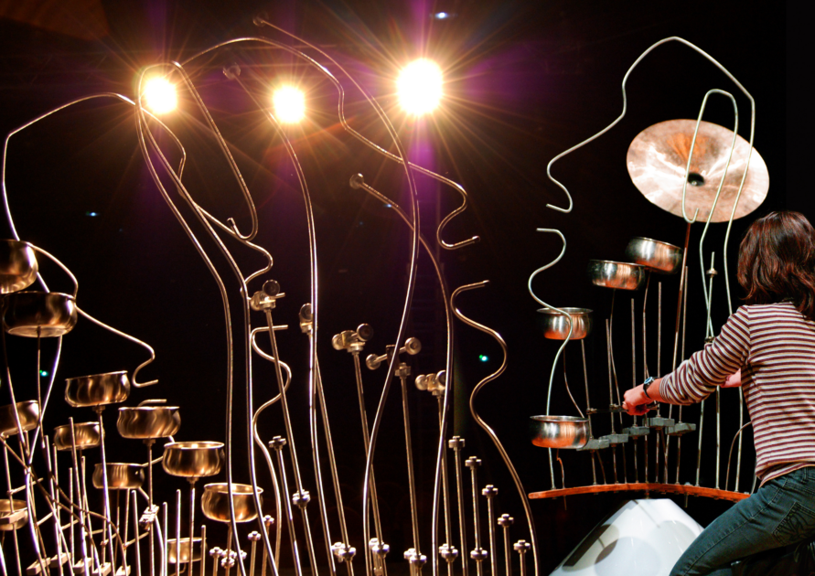 Femme jouant sur une sculpture sonore en formes de visages
